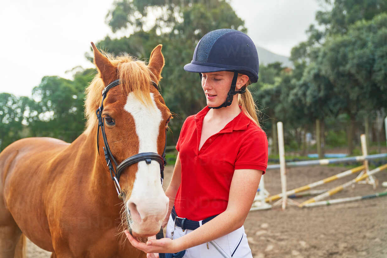 files/teenage-girl-in-equestrian-helmet-with-horse-in-paddock-CAIF24261.jpg